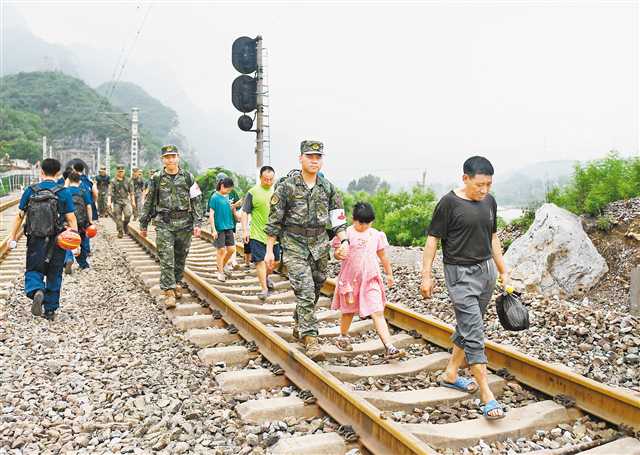 八月二日，部分滯留旅客在救援人員的幫助下前往轉運客車.jpg